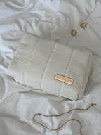 White makeup bag with 'LIA STUDIO' label on a white textured surface.